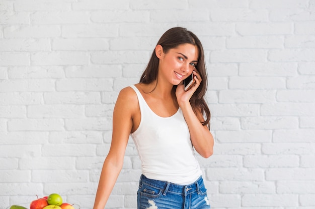 Sonriente joven hablando por teléfono móvil