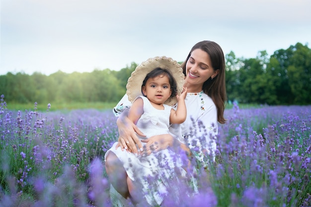 Sonriente joven madre posando con niños en campo lavanda