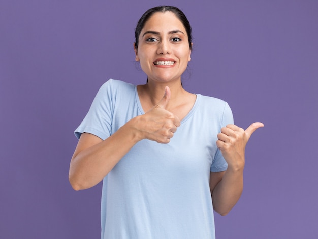 Sonriente joven morena caucásica hojeando con las dos manos en púrpura