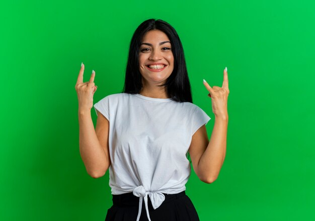 Sonriente joven mujer caucásica gestos cuernos signo de mano con las dos manos