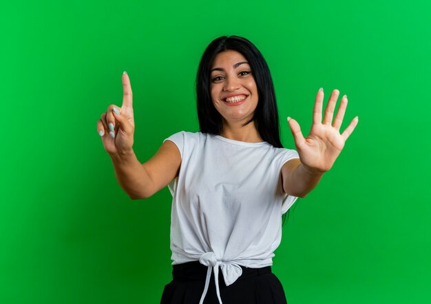 Sonriente joven mujer caucásica gestos seis con los dedos