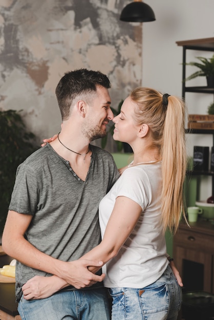 Foto gratuita sonriente joven pareja romántica amándose