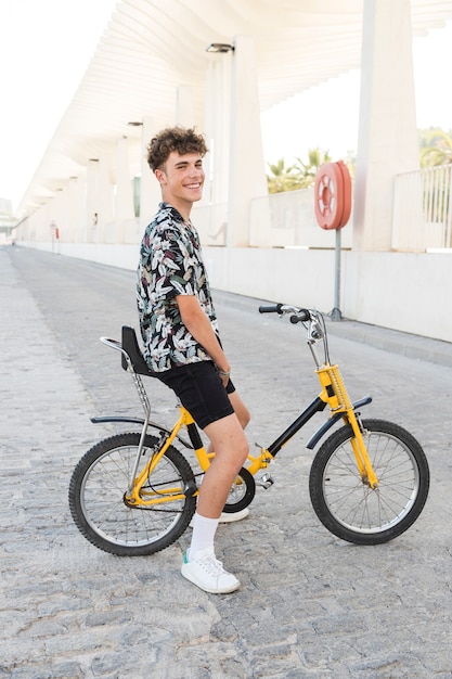 Sonriente joven sentado en bicicleta