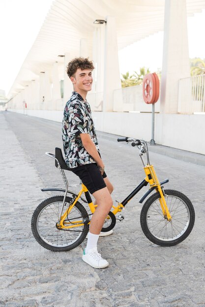 Sonriente joven sentado en bicicleta