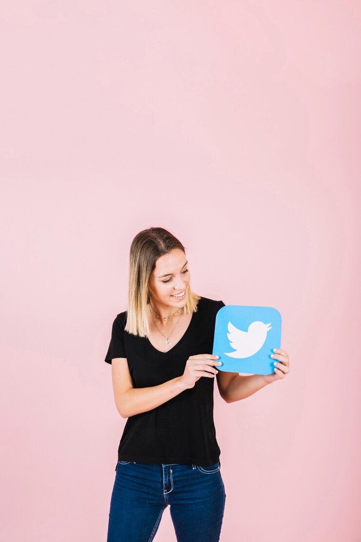 Foto gratuito sonriente joven sosteniendo icono de twitter