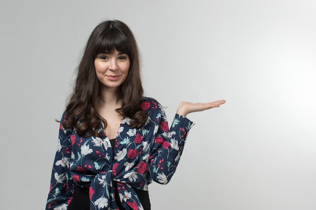 sonriente jovencita en camiseta diseñada de buen humor con el pelo largo en blanco