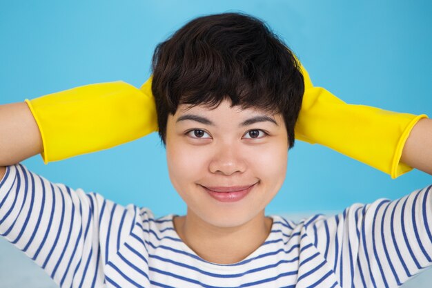 Sonriente linda chica asiática con guantes de protección