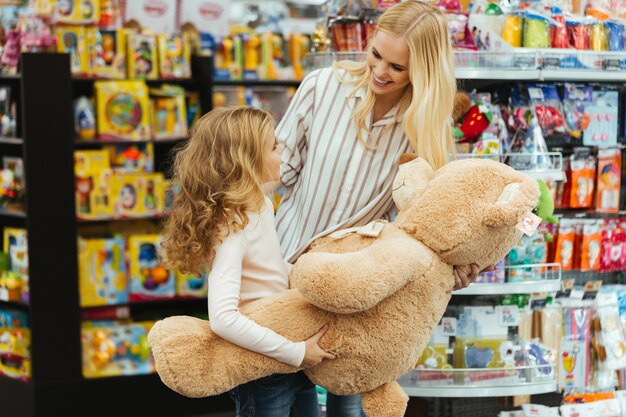 Sonriente madre e hija de pie en el supermercado