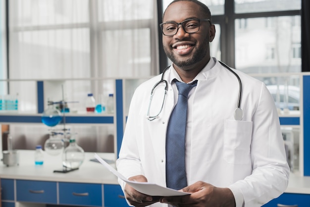 Sonriente médico negro con papeles