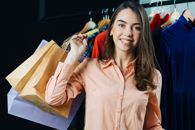 Sonriente morena con bolsas de papel