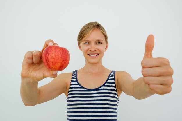 Sonriente, mujer, actuación, manzana, thumb-up