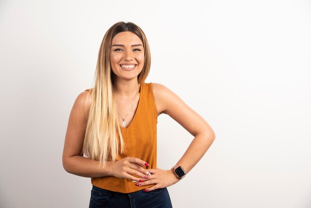 Sonriente mujer adulta bastante joven mirando a cámara y posando.