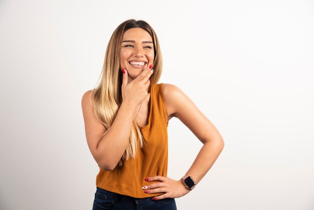 Sonriente mujer adulta bastante joven mirando a cámara y posando.