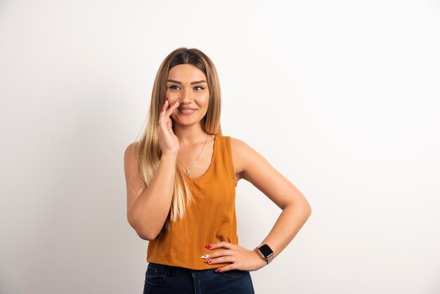 Sonriente mujer adulta bastante joven mirando a cámara y posando.