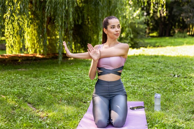 Sonriente mujer atlética está haciendo yoga