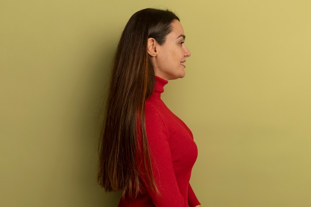 Foto gratuita sonriente mujer bonita caucásica se encuentra de lado en verde oliva