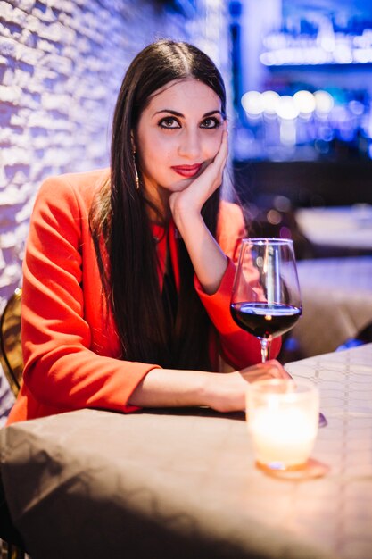 Sonriente mujer en chaqueta roja en el restaurante