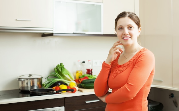 Sonriente mujer en la cocina doméstica