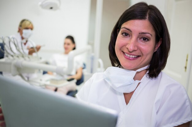 Sonriente mujer dentista en clínica dental