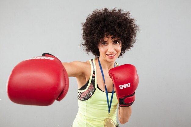 Sonriente mujer deportiva despreocupada boxeo a la cámara