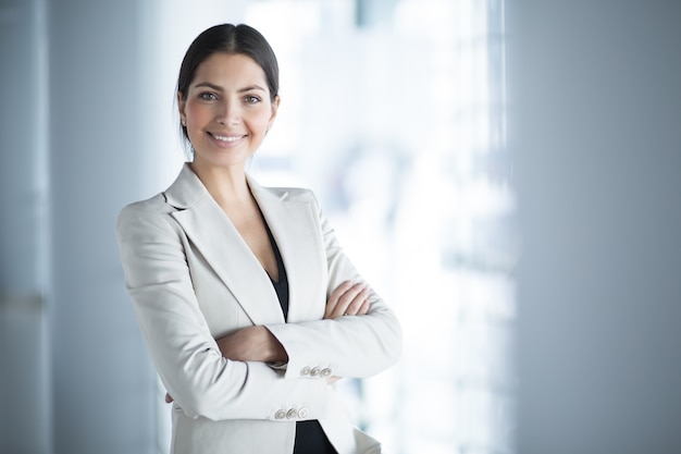 Foto gratuita sonriente, mujer, empresa, líder, brazos, cruzado