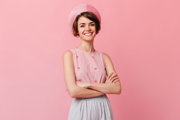 Sonriente mujer encantadora posando con los brazos cruzados