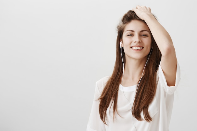 Sonriente mujer feliz disfrutando de escuchar música en auriculares