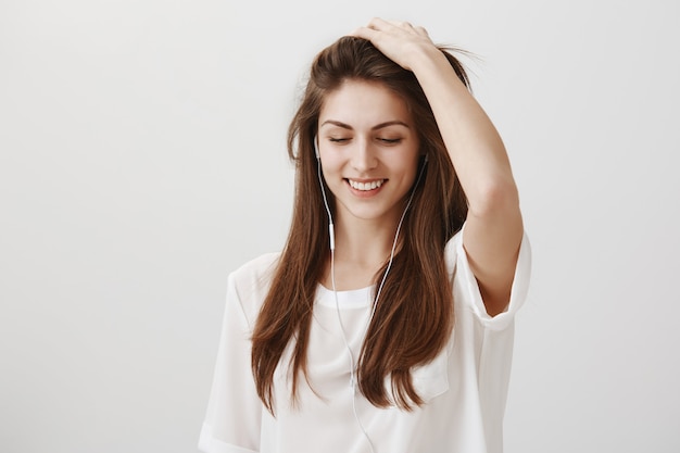 Sonriente mujer feliz disfrutando de escuchar música en auriculares