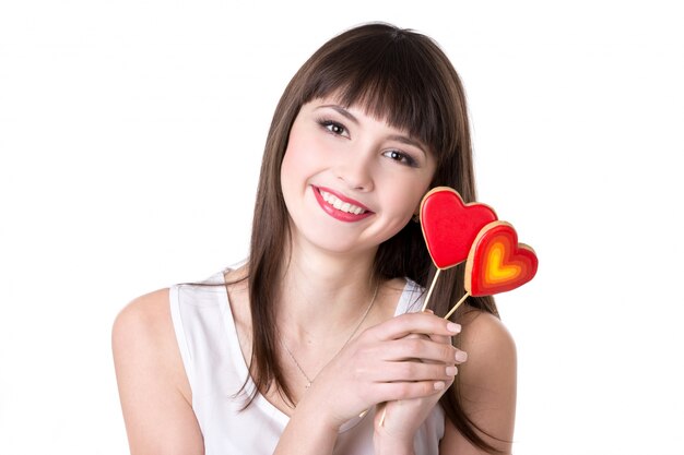 Sonriente mujer con galletas en forma de corazón