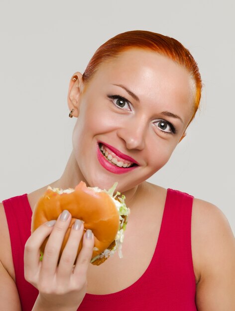 Sonriente mujer con hamburguesa