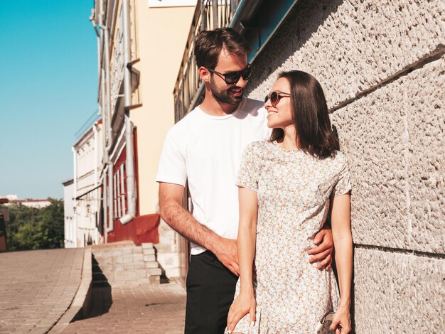 Sonriente mujer hermosa y su guapo novio Mujer en ropa casual de verano Familia alegre feliz Mujer divirtiéndose Pareja posando en el fondo de la calle Abrazándose unos a otros al atardecer