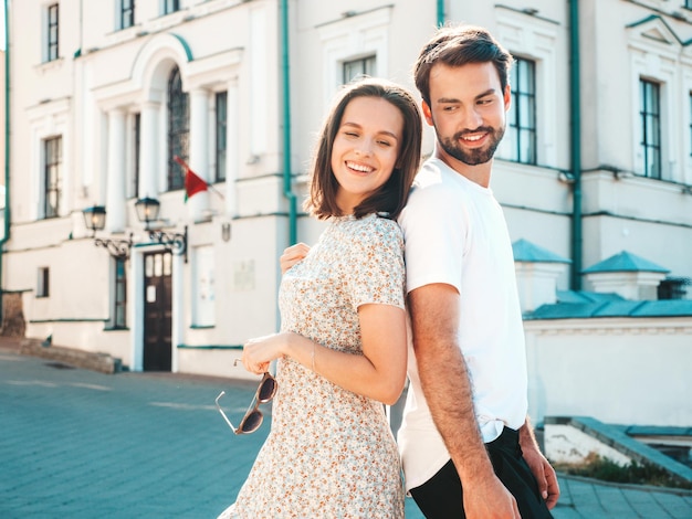 Sonriente mujer hermosa y su guapo novio Mujer en ropa casual de verano Familia alegre feliz Mujer divirtiéndose Pareja posando en el fondo de la calle Abrazándose unos a otros al atardecer