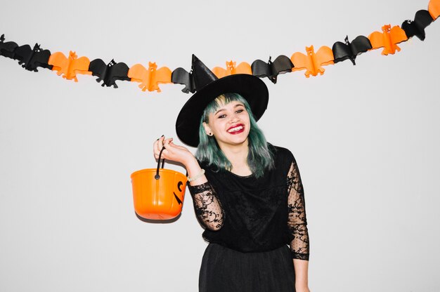 Sonriente mujer joven con bolsa de calabaza