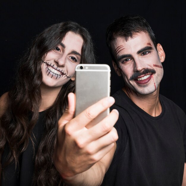 Sonriente mujer joven y chico tomando selfie