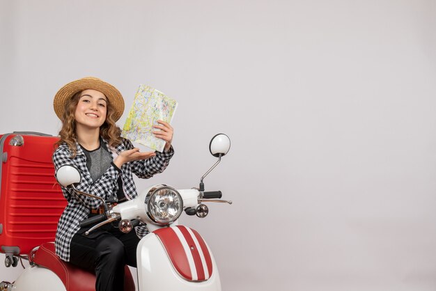 sonriente, mujer joven, en, ciclomotor, tenencia, mapa, gris