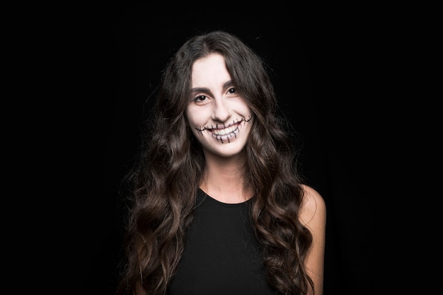 Sonriente mujer joven con maquillaje espeluznante