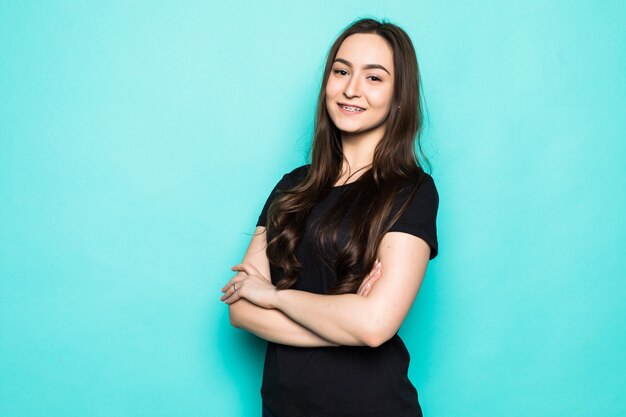 Sonriente mujer joven posando aislada en la pared azul turquesa. Concepto de estilo de vida de personas.