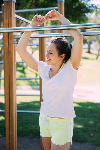 Sonriente, mujer joven, posición, por, barras mono