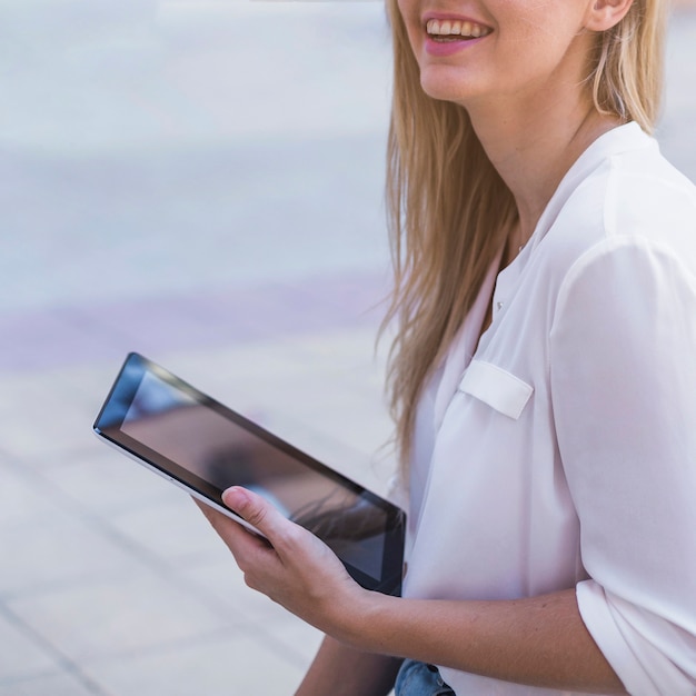 Sonriente mujer joven con tableta digital