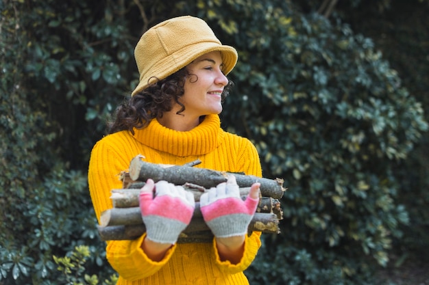 Sonriente mujer con leña