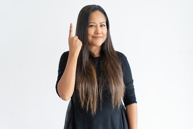 Foto gratuita sonriente mujer de mediana edad apuntando hacia arriba