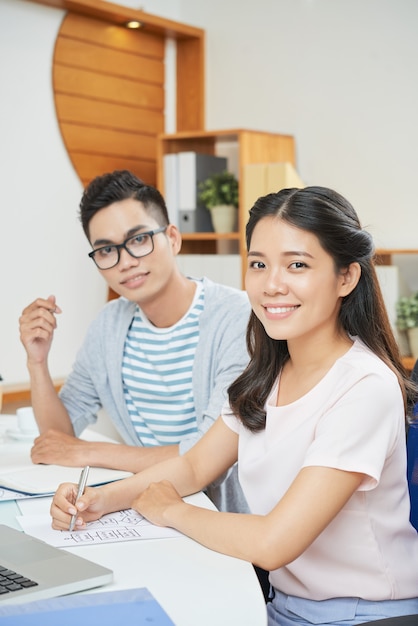 Sonriente mujer moderna con hombre en oficina