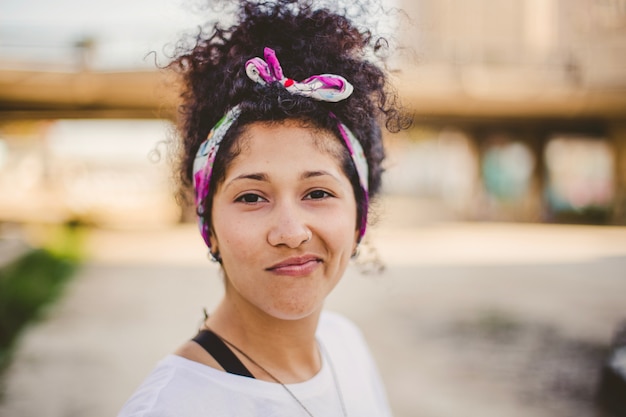 Sonriente mujer morena de pie fuera