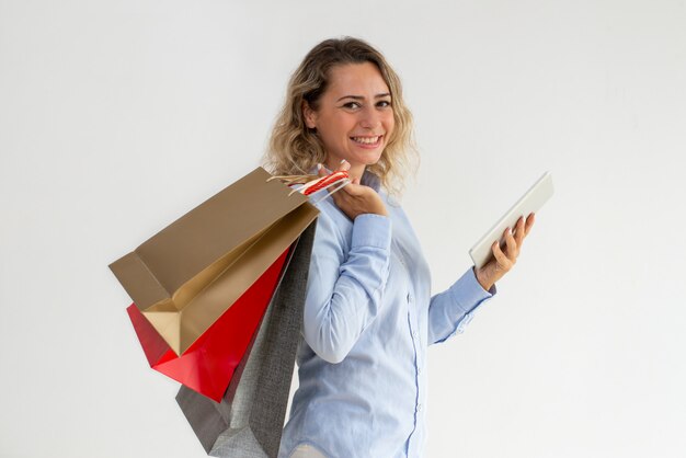 Sonriente mujer optimista con tableta para compras en línea