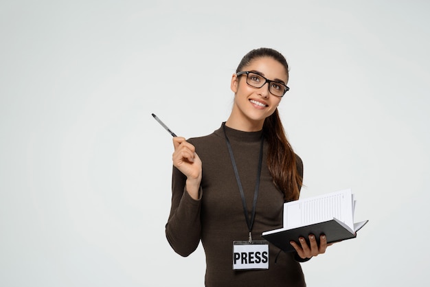 Sonriente mujer periodista escribiendo, entrevistando