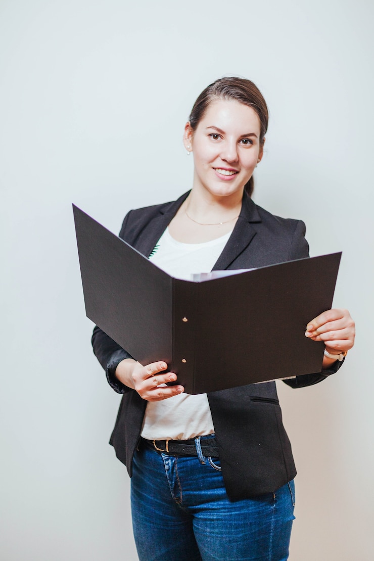 Foto gratuito sonriente mujer de pie con la carpeta