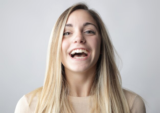 Sonriente mujer rubia detrás de blanco