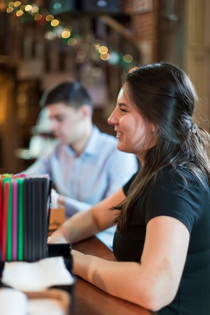 Sonriente mujer sentada en el mostrador