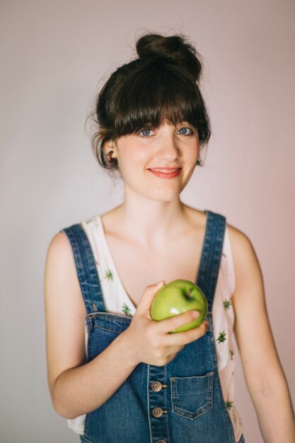 Sonriente mujer sosteniendo la manzana