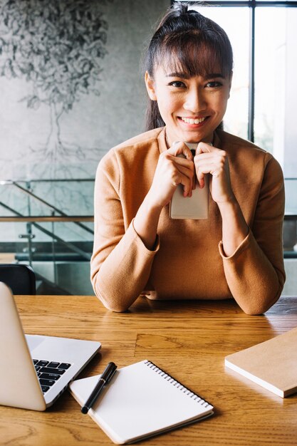 Sonriente mujer sosteniendo teléfono